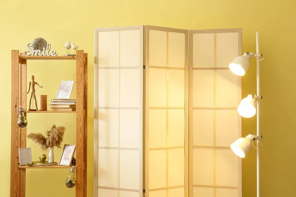 Folding Screen Glowing Lamp Shelving Unit Yellow Wall — Stock Photo, Image
