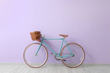Leylak duvarının yanında hasır sepeti olan modern bisiklet.