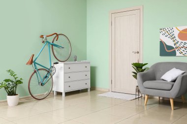 Bisikletli, sandıklı ve koltuklu şık bir oturma odası.