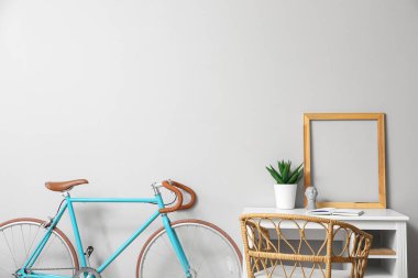 Işık duvarının yanında çerçevesi ve bisikleti olan modern işyeri