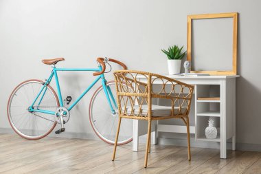 Işık duvarının yanında çerçevesi ve bisikleti olan modern işyeri