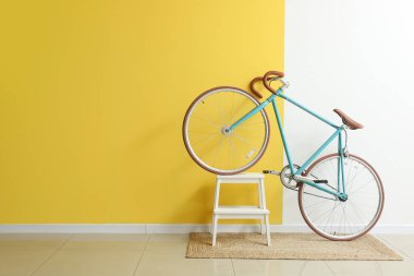 Sarı ve beyaz duvarın yanında merdiveni olan modern bisiklet.