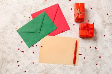 Hediye kutuları, konfetiler, zarflar, arka planda kalem ve boş mektuplar