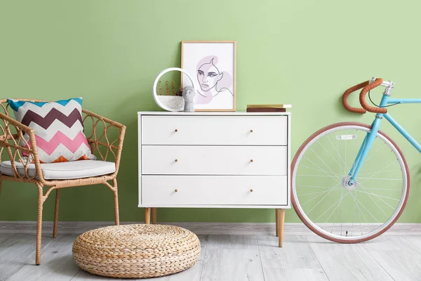 Sandalyesi, çekmecesi ve bisikleti olan şık bir oda.