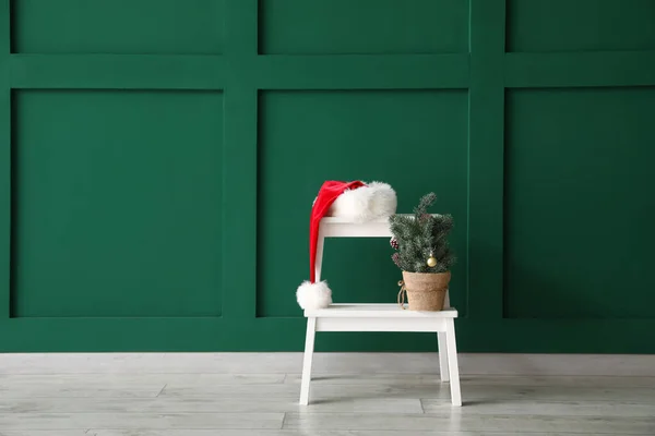 White Step Stool Santa Hat Small Christmas Tree Green Wall — Stock Photo, Image