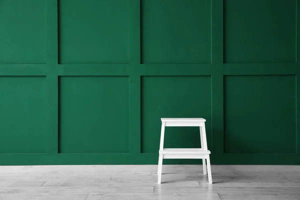 緑の壁の近くの白い足踏みスツール — ストック写真