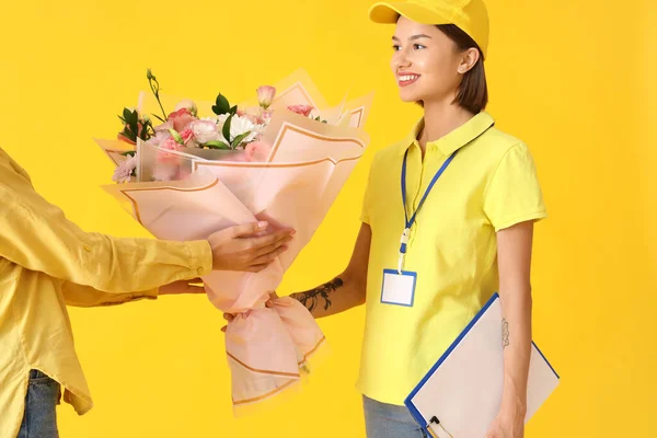 Frau Erhält Blumenstrauß Von Kurier Auf Farbigem Hintergrund — Stockfoto