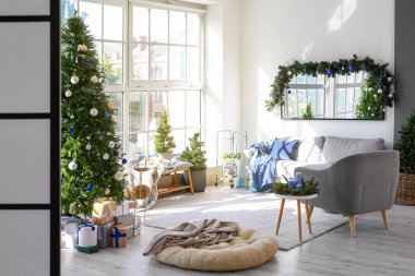 İçinde Noel ağacı olan dekore edilmiş bir oturma odası.