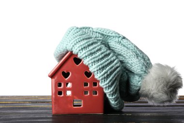 Beyaz arka planda sıcak şapkalı oyuncak evi. Kış konsepti