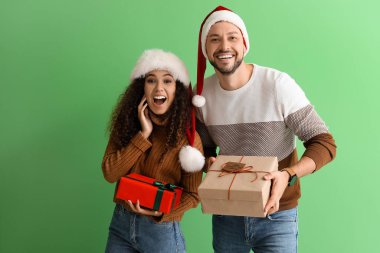 Mutlu çift, renkli arka planda Noel hediyeleri ile