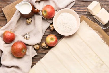 Tahta arka planda elmalı turta için taze hamur ve malzemeler.