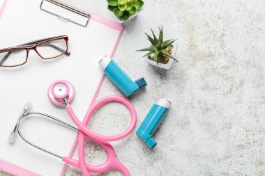 Pano, gözlük, ev bitkileri, steteskop ve astım spreyleri.
