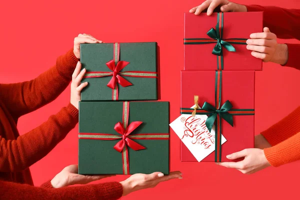 Manos Femeninas Con Diferentes Cajas Regalo Navidad Sobre Fondo Rojo — Foto de Stock
