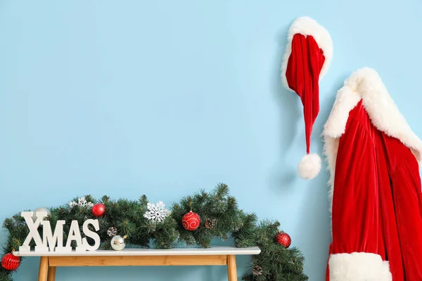 Mesa Decorada Con Palabra Xmas Traje Papá Noel Colgando Pared — Foto de Stock