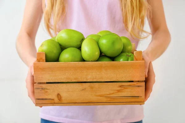 Frau Hält Holzkiste Mit Frischen Grünen Tomaten Auf Hellem Hintergrund — Stockfoto