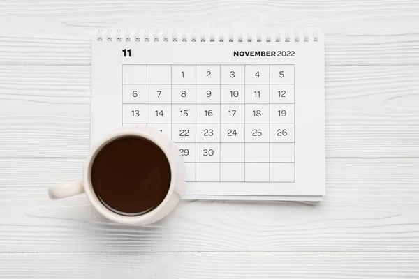 Papierkalender Mit Tasse Kaffee Auf Weißem Holzhintergrund — Stockfoto