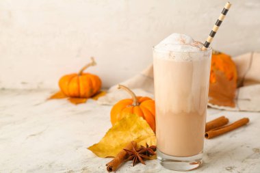 Hafif arkaplanda bir bardak lezzetli balkabaklı latte.