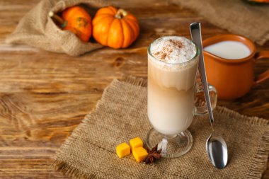 Ahşap zemin üzerinde bir bardak lezzetli balkabağı lattesi.