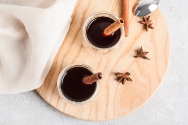 Hafif arka planda tarçınlı bir bardak lezzetli kahve.