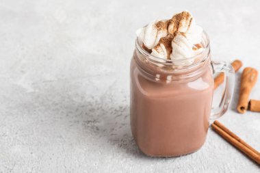 Mason kavanozu tarçınlı lezzetli kahve ve hafif arkaplanda marşmelov.