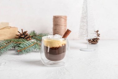 Beyaz arka planda tarçınlı bir bardak lezzetli kahve.