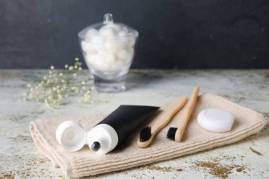 Aktif karbon, fırça, diş ipi ve havlu içeren siyah diş macunu.