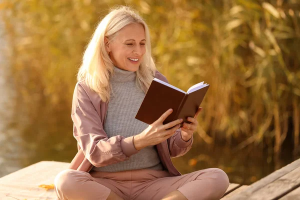 Mature Woman Reading Book River Autumn Day — Stock Photo, Image