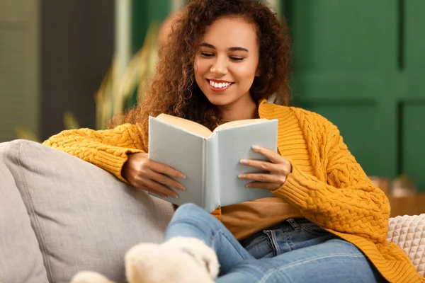 Young African American Woman Yellow Cardigan Reading Book Sofa Home — Stock Photo, Image