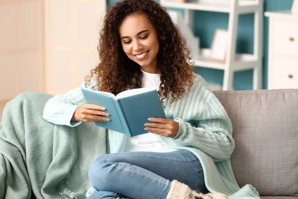 Young African American Woman Warm Cardigan Reading Book Sofa Home — Stock Photo, Image