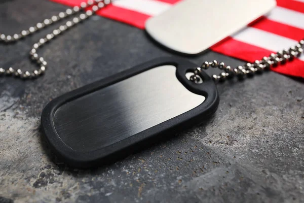 Koyu arka planda ABD bayrağı ve askeri etiketleri, yakın plan.