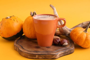 Sarı arka planda bir fincan lezzetli kabak kahvesi ve sebze.