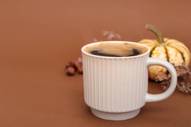 Kahverengi arka planda bir fincan lezzetli kabak kahvesi.