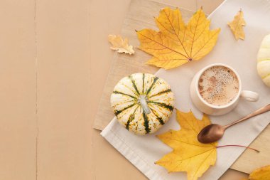 Bej ahşap arka planda bir fincan lezzetli balkabağı kahvesi.