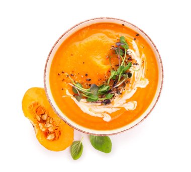 Beyaz arka planda balkabağı kremalı çorba.