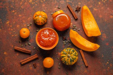 Bir kase dolusu tatlı balkabağı reçeli ve arkaplanda portakallar.