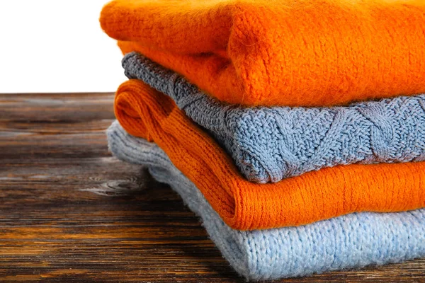 Stack Blue Orange Sweaters Wooden Table White Background Closeup — Stock Photo, Image