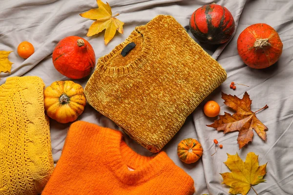 灰色の生地の背景にスタイリッシュなセーターや秋の装飾 — ストック写真