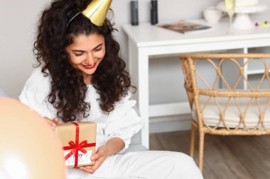 Coronavirüs salgınından dolayı doğum gününü evde kutlayan genç bir kadın.