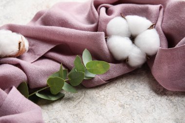 Kumaş, pamuk çiçekleri ve okaliptüs dalı grunge masasında.