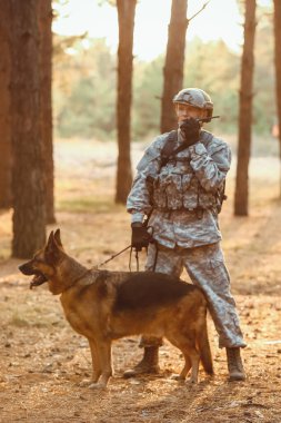 Dışarıdaki savaş sırasında askeriyede çalışan köpeği olan bir asker.