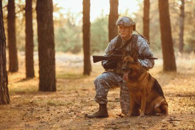 Dışarıdaki savaş sırasında askeriyede çalışan köpeği olan bir asker.