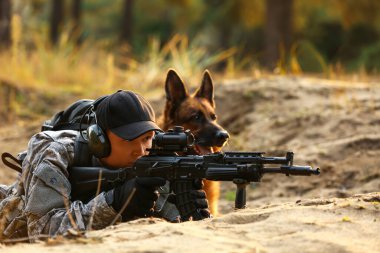 Dışarıdaki savaş sırasında askeriyede çalışan köpeği olan bir asker.