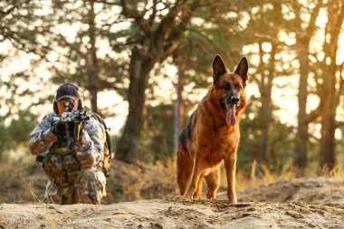 Dışarıdaki savaş sırasında askeriyede çalışan köpeği olan bir asker.