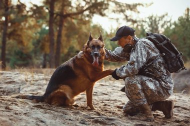 Asker köpeği dışarıdaki askere pençe veriyor.
