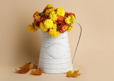 Bej arka planda güzel kasımpatı çiçekleri olan su kutusu.