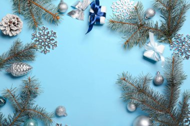 Mavi arka planda hediye kutuları, toplar ve köknar dallarıyla Noel kompozisyonu