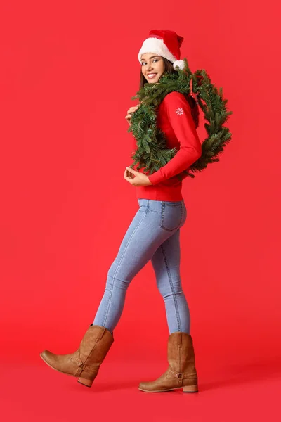 Schöne Wandelnde Junge Frau Mit Weihnachtskranz Auf Farbigem Hintergrund — Stockfoto