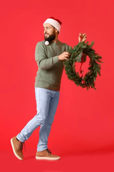 Gehender Mann Mit Weihnachtskranz Auf Farbigem Hintergrund — Stockfoto