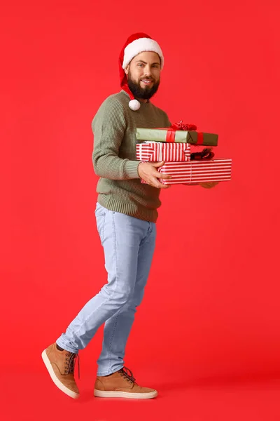 Gehender Mann Mit Weihnachtsgeschenken Auf Farbigem Hintergrund — Stockfoto