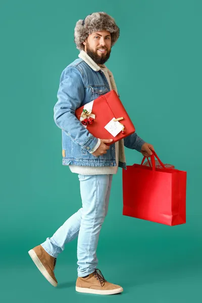 Περπάτημα Άνθρωπος Δώρο Χριστουγέννων Και Τσάντα Ψώνια Στο Φόντο Χρώμα — Φωτογραφία Αρχείου